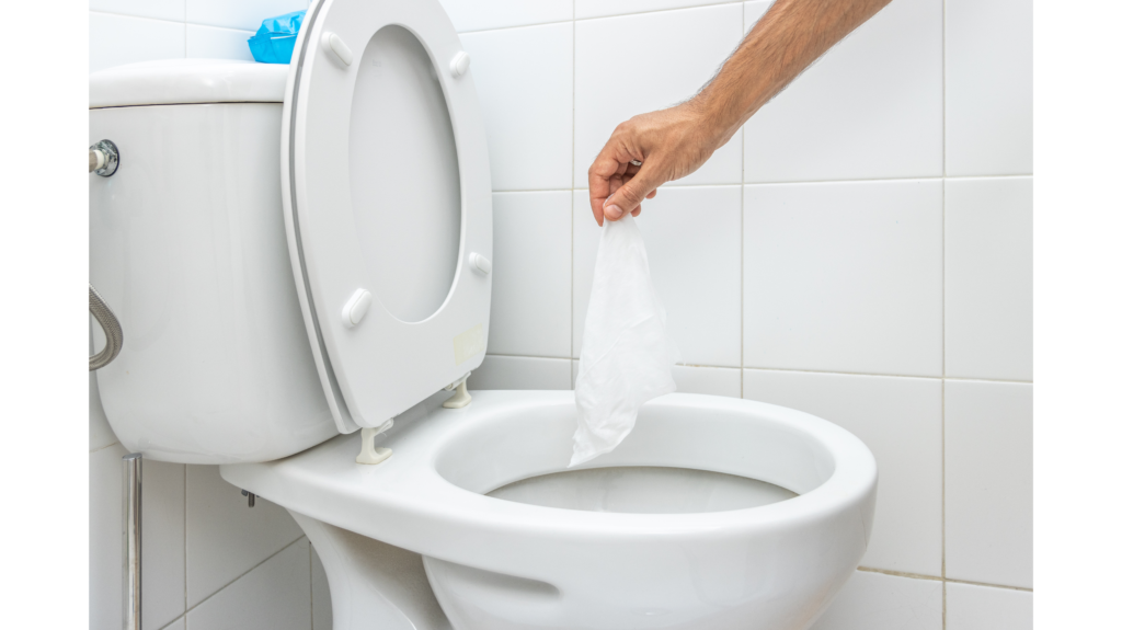 hand holding wipe over open toilet before flushing
