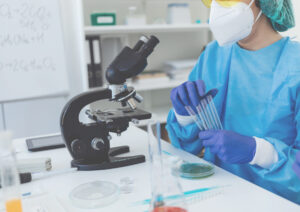 Scientist working with a microscope and test tubes
