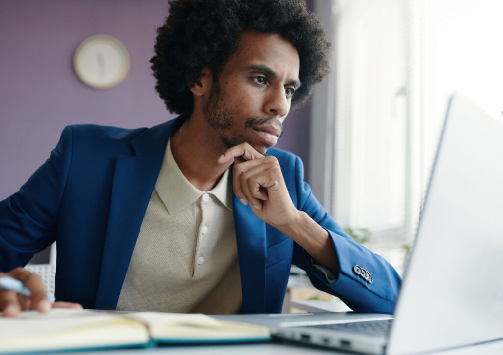 Young man in blue jacket working on laptop